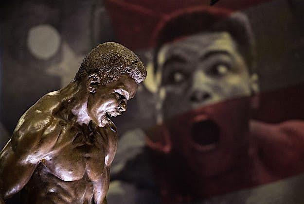 Travel News - GettyImages-513466872 A statue of Muhammad Ali on display in front of posters - at the preview of the 'I Am The Greatest' Muhammad Ali exhibition on March 3, 2016 in London, England. The exhibition showcases the life and career of heavyweight boxer Muhammad Ali and features over more than 100 artefacts including personal memorabilia, unseen footage and photographs. It is open to the public from Friday March 4, 2016 at the O2 in London.