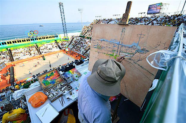 Travel News - GettyImages-587765770 An artist paints the scene during the men's beach volleyball qualifying match between Latvia and Cuba at the Beach Volley Arena in Rio de Janeiro on August 9, 2016, during the Rio 2016 Olympic Games.