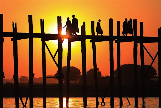 Travel News - Myanmar Dietmar Temps500px_29075291 Buddhist monks crossing the U-Bein bridge at sunset, Amarapura, Myanmar.