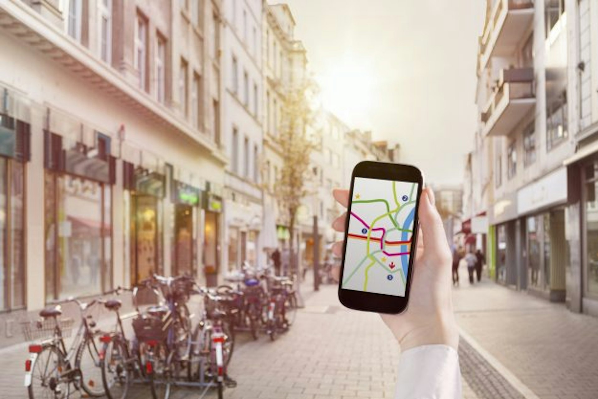 Travel News - Hand holding smart phone with map app in city