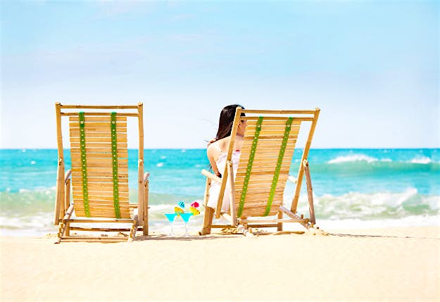 Travel News - gettyimages-523138789-copy Woman enjoys a drink on the beach.