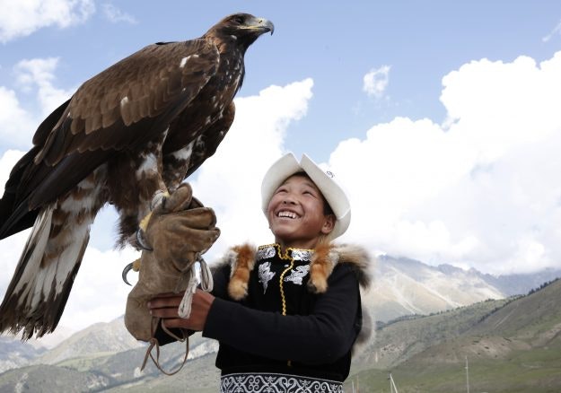 A boy handles an eagle at the World Nomad Games 2016 in Kyrchyn Gorge, Kyrgyzstan. 