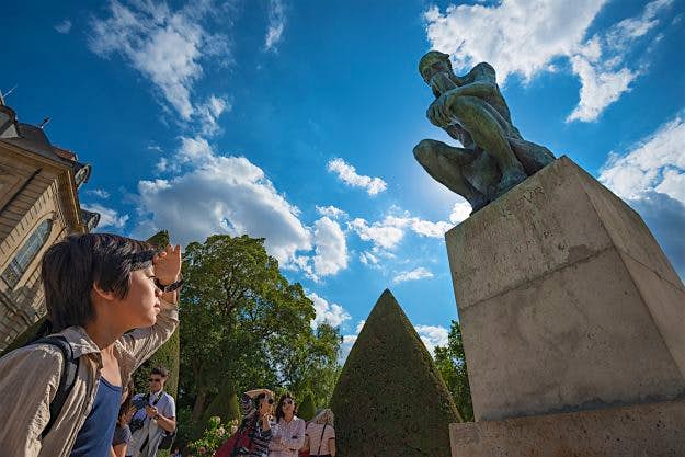 Travel News - Tourists visiting the statue of the Thinker at the Museum of Rodin. Paris comes out top for learning the language.