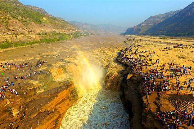 Travel News - gettyimages-612089194 Aerial view of tourists visiting the Hukou Waterfall during the National Day holiday on October 2, 2016 in Yan'an, Shaanxi Province of China. The Hukou Waterfall on the Yellow River attracted thousands of tourists on the second day of the 7-day National Day holiday.
