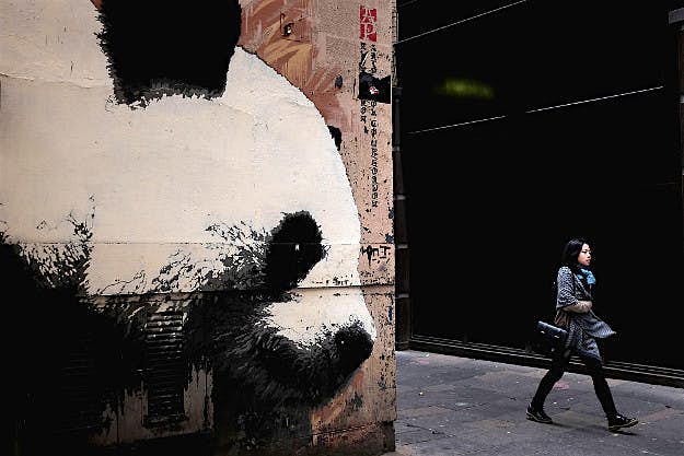 Travel News - gettyimages-618294144 A woman walks past a mural of a Panda in Gordon Lane.