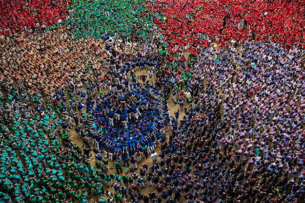 Travel News - humantowers2 Members of the colla 'Castellers de la Vila de Gracia' climb up as they construct a human tower during the 26th Tarragona Competition on October 2, 2016 in Tarragona, Spain.