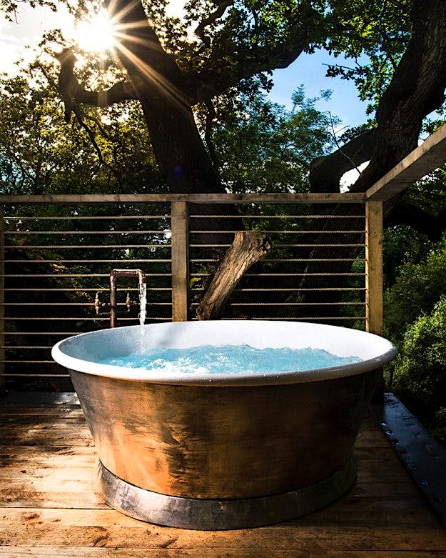 Travel News - 1-1craftycamping-thewoodsmanstreehouse-hot-tub The site features a sauna and copper tubs.