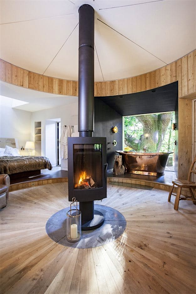 Travel News - 1-3craftycamping-thewoodsmanstreehouse-bed-fire-bath A rotating burner adds extra comfort in every season.