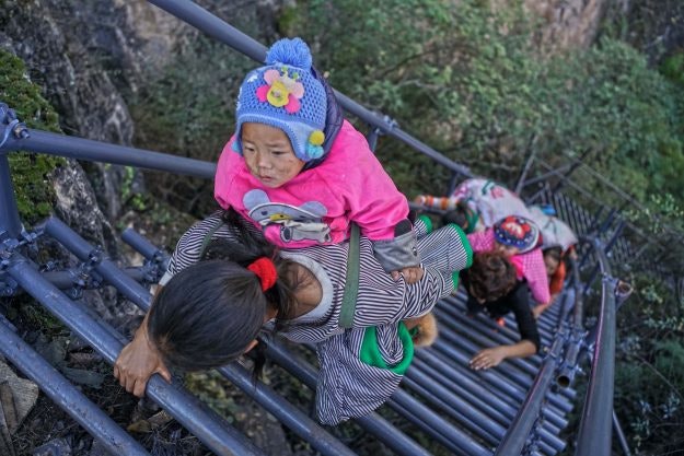 A steel ladder creates a safer path for cliff village children in China. Image: imaginechina