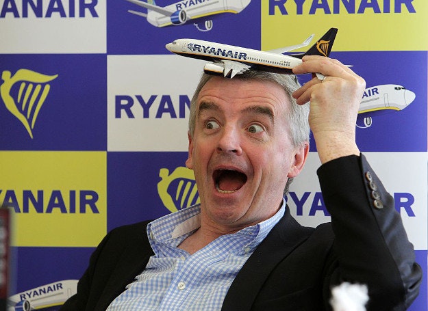 Michael O'Leary, CEO of Ryanair, holding a toy plane to his forehead