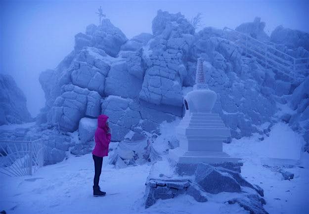 Travel News - Yulia Gasheva praying at a stupa which is for prayers directed at other people. Yulia Gasheva praying at a stupa.