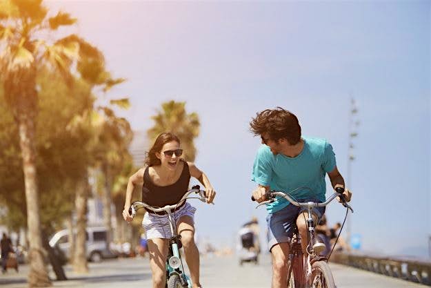 Travel News - Woman chasing man while riding bicycle A bicycle ferry is being trialled between Denmark and Sweden. Image: Morsa Images