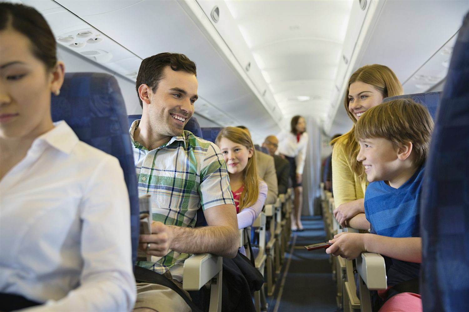 Travel News - Smiling family traveling in airplane A smiling family is traveling in airplane.