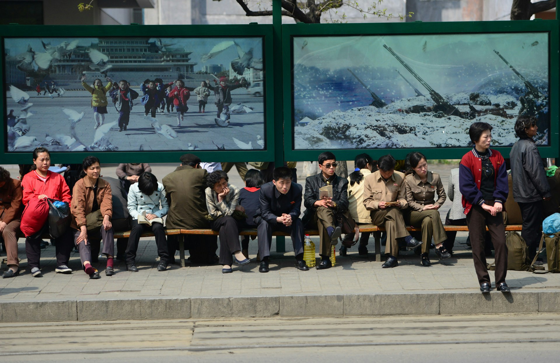 North Korean people site at a bus stop in Pyongyang.