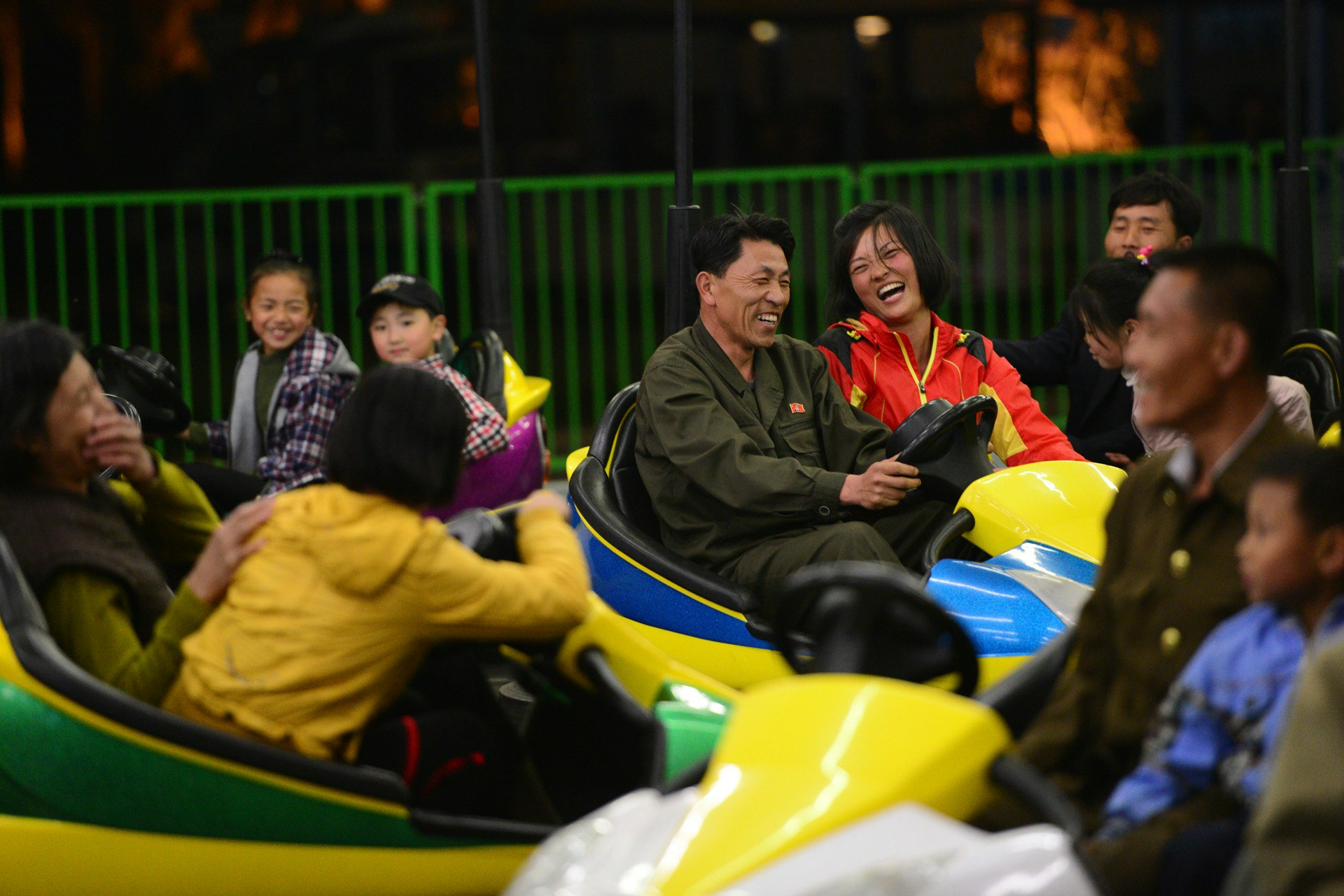 Two people share a laugh at the Pyongyang Amusement park, which featured bumper cars, a roller coaster and other rides. 