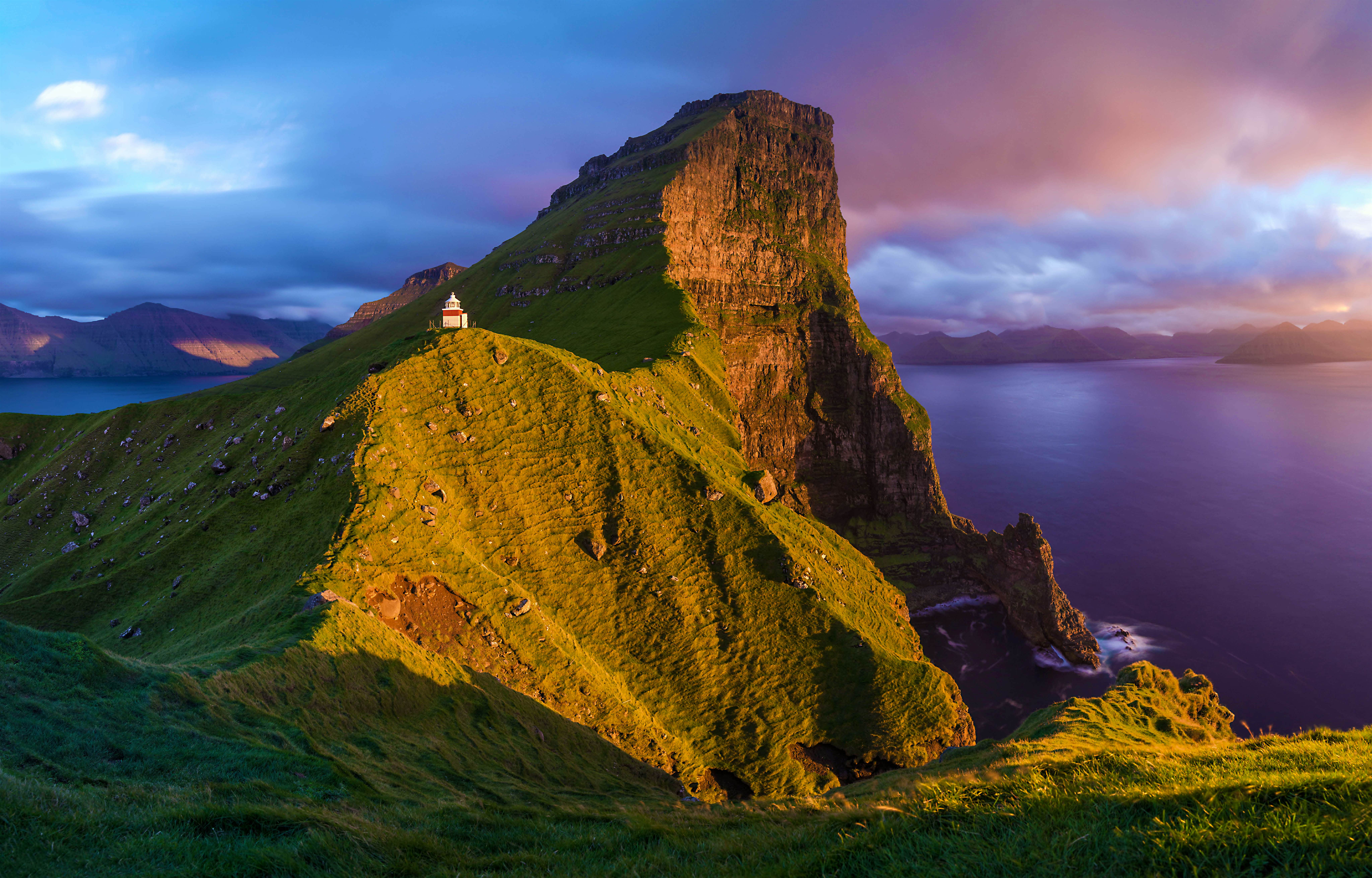 Travel News - GettyImages-641602004 The western coast of Kalsoy in the Faroe Islands has dramatically steep cliffs for the full length of the island, whereas idyllic valleys on the eastern slopes protect the four tiny settlements, whose combined populations total less than 150.