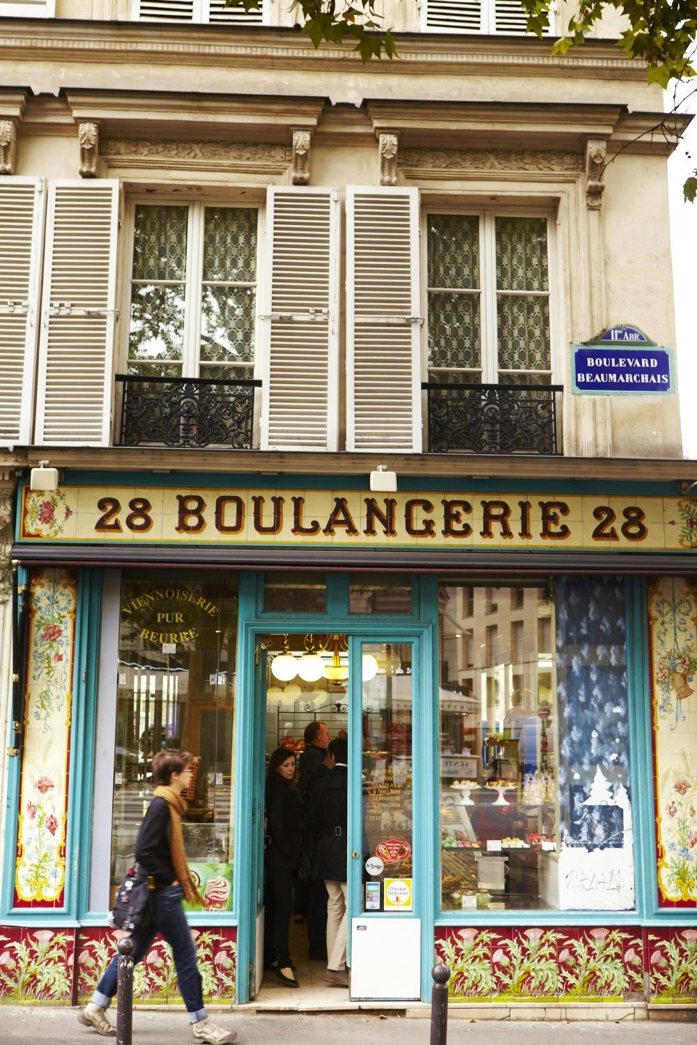 Woman walking past La Boulangerie, France.