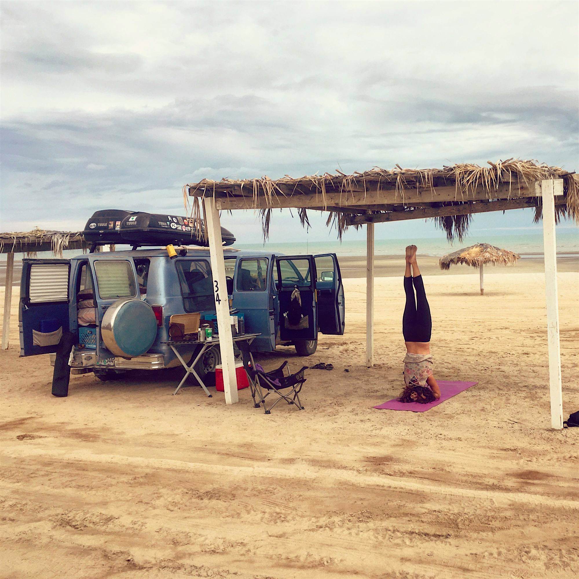 Travel News - We live here now Emily practising yoga on the beach.