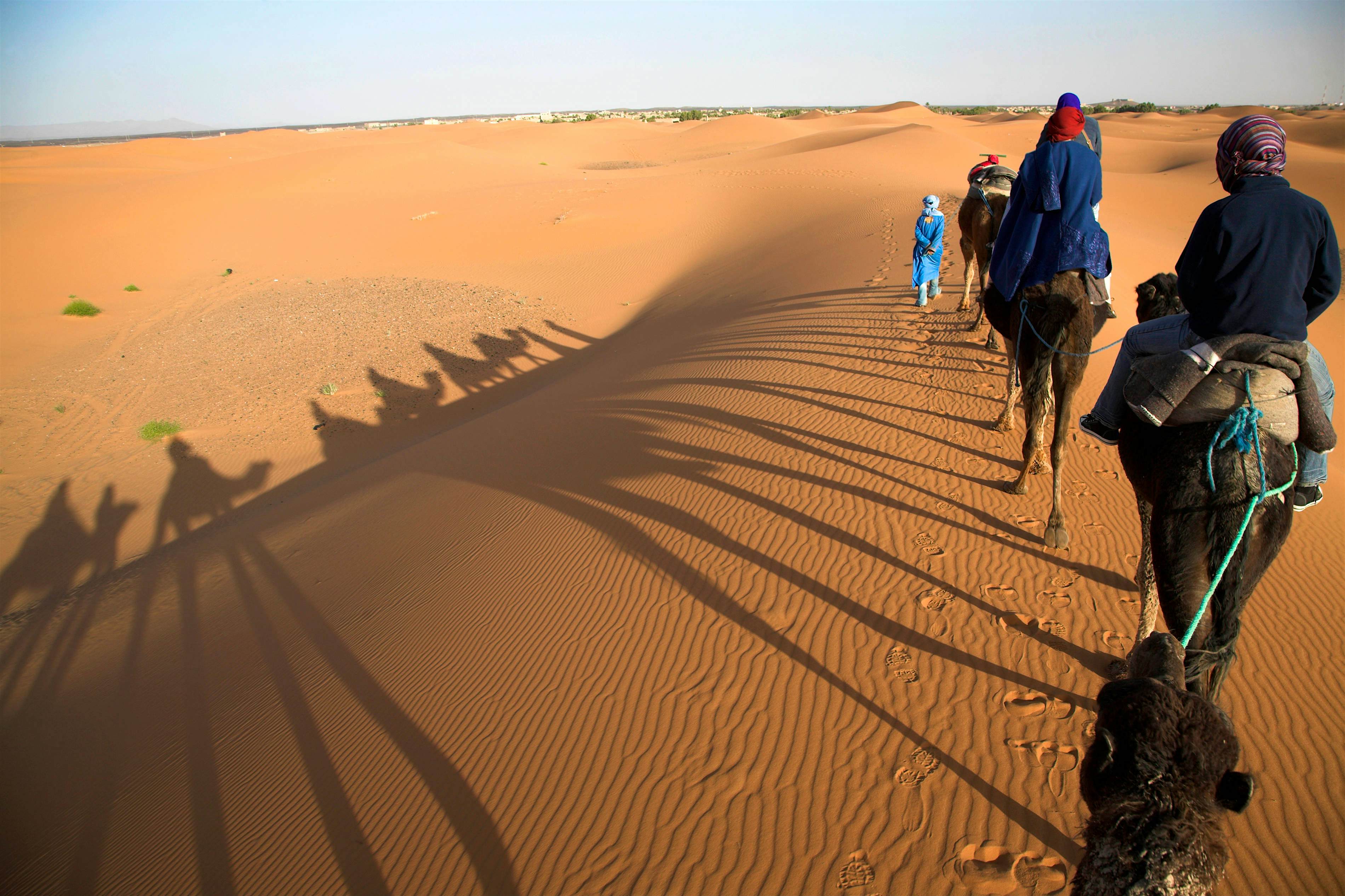 Travel News - Tourists on camel trek through sand dunes in the Sahara desert at Merzouga, Morocco GettyImages-558239527 Camel trek in the Sahara desert