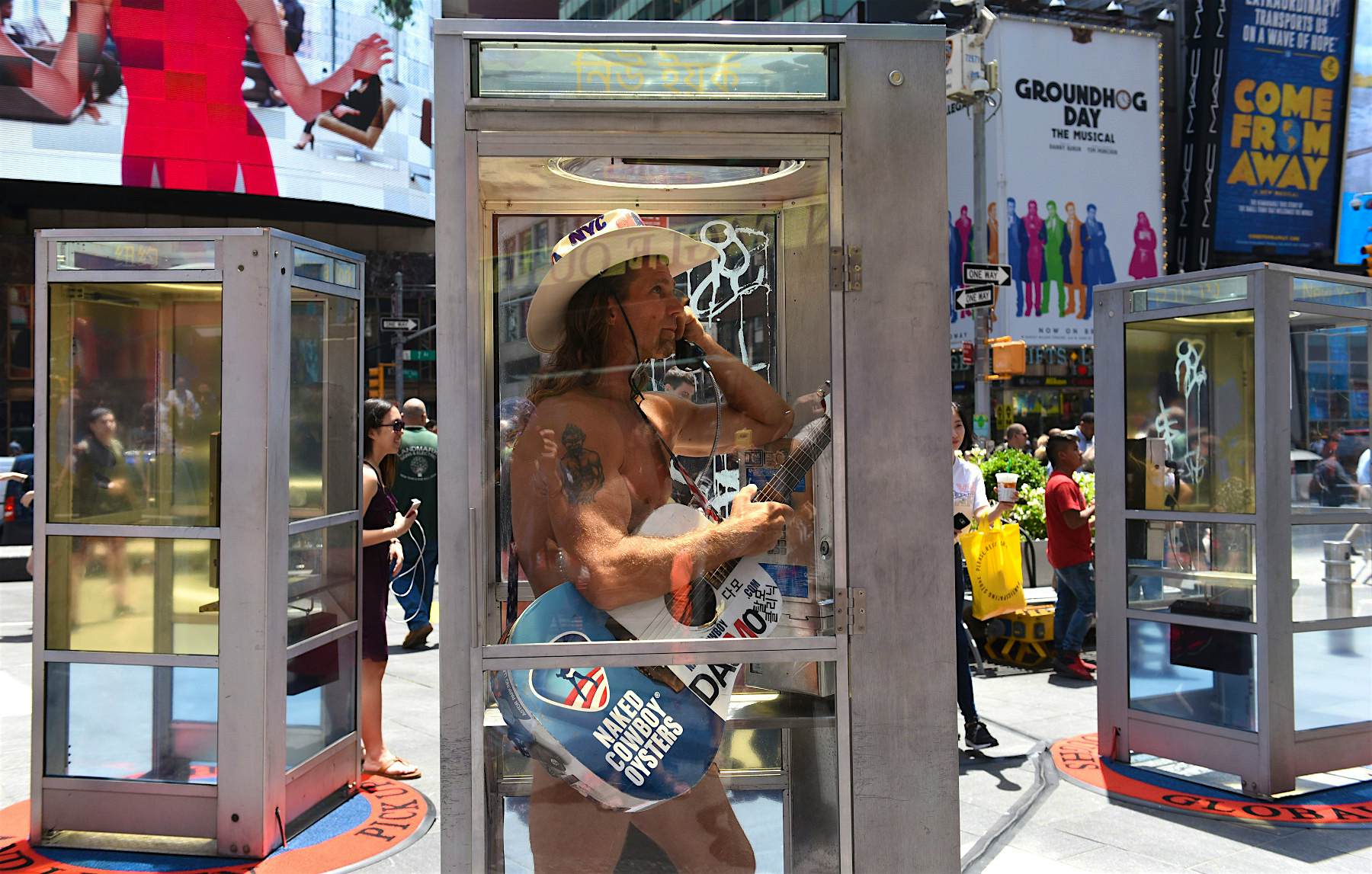 Travel News - immigrant art installation times square The Naked Cowboy stops by to listen to immigrants' stories in phone booths in Times Square