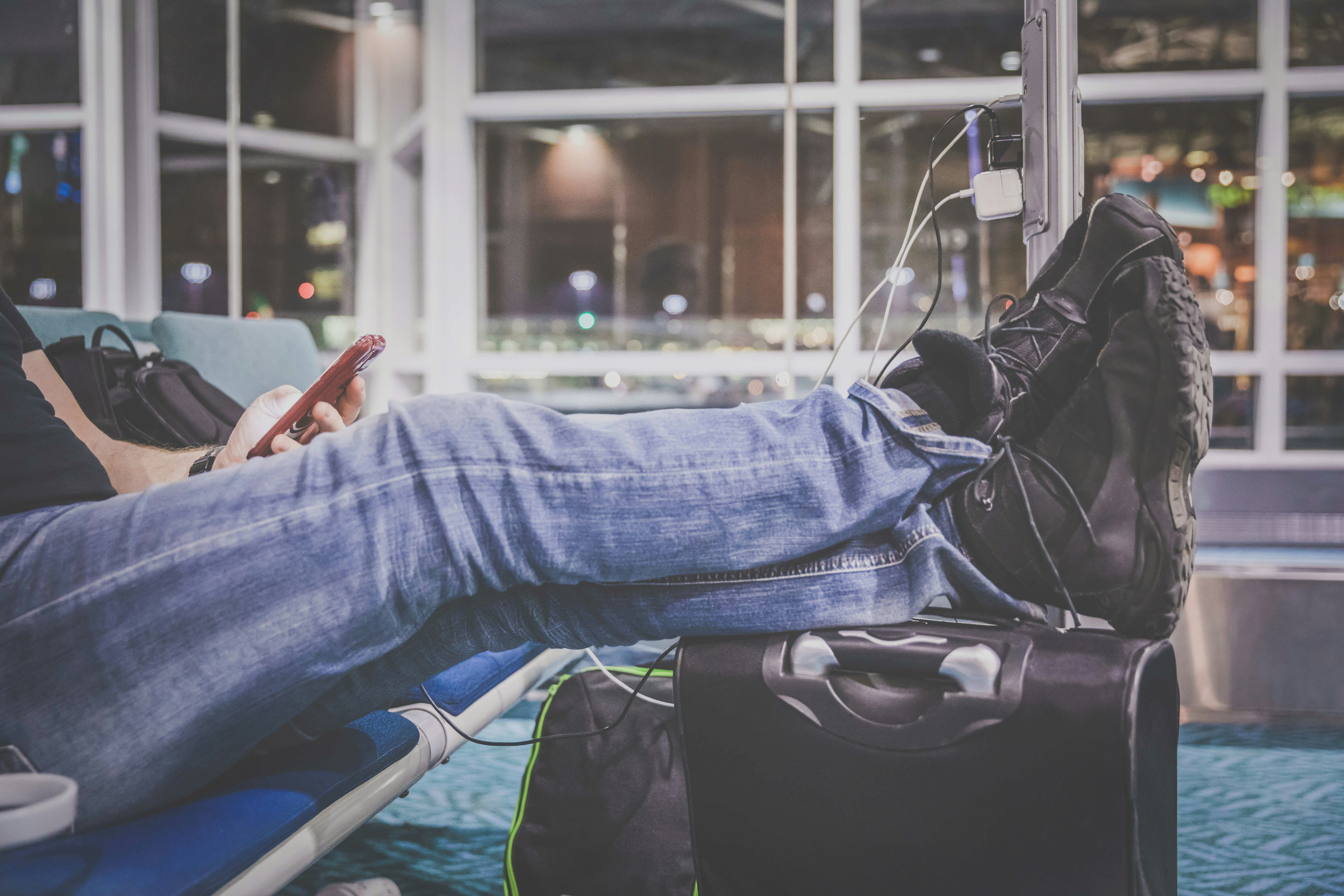 Man Using Mobile Phone and Charging Station at Airport