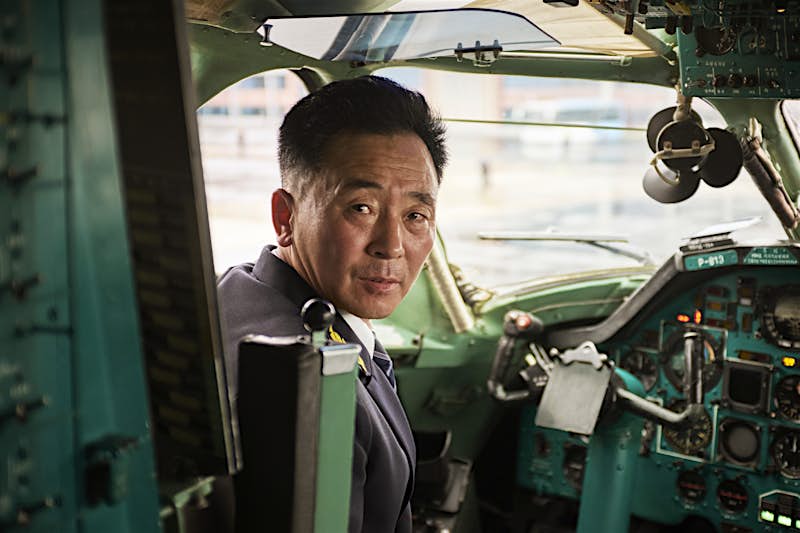 Travel News - Dear-Sky_┬®_Arthur-Mebius_52 North Korea Airline Photos of North Korea Koryo An Air Koryo pilot looks back from the cockpit of an aircraft.