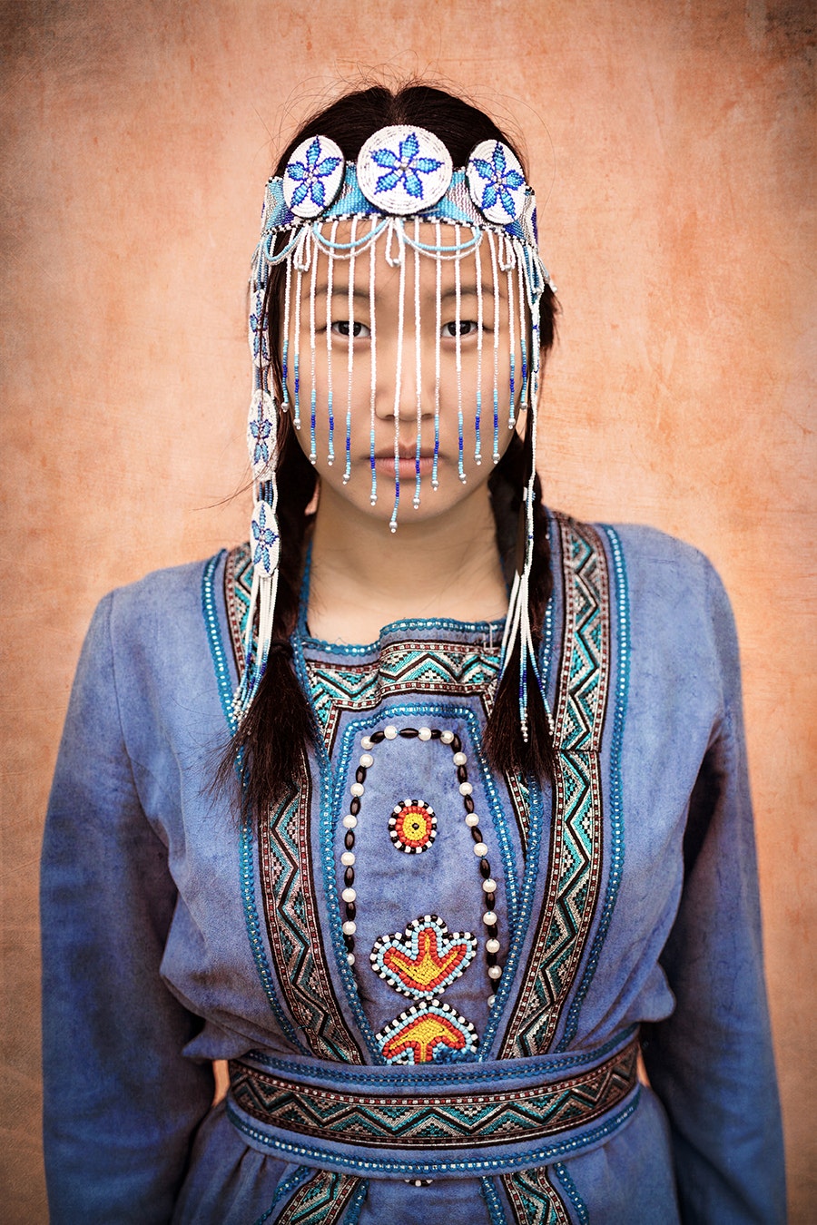 A girl poses for the camera in traditional Evenki clothing. 