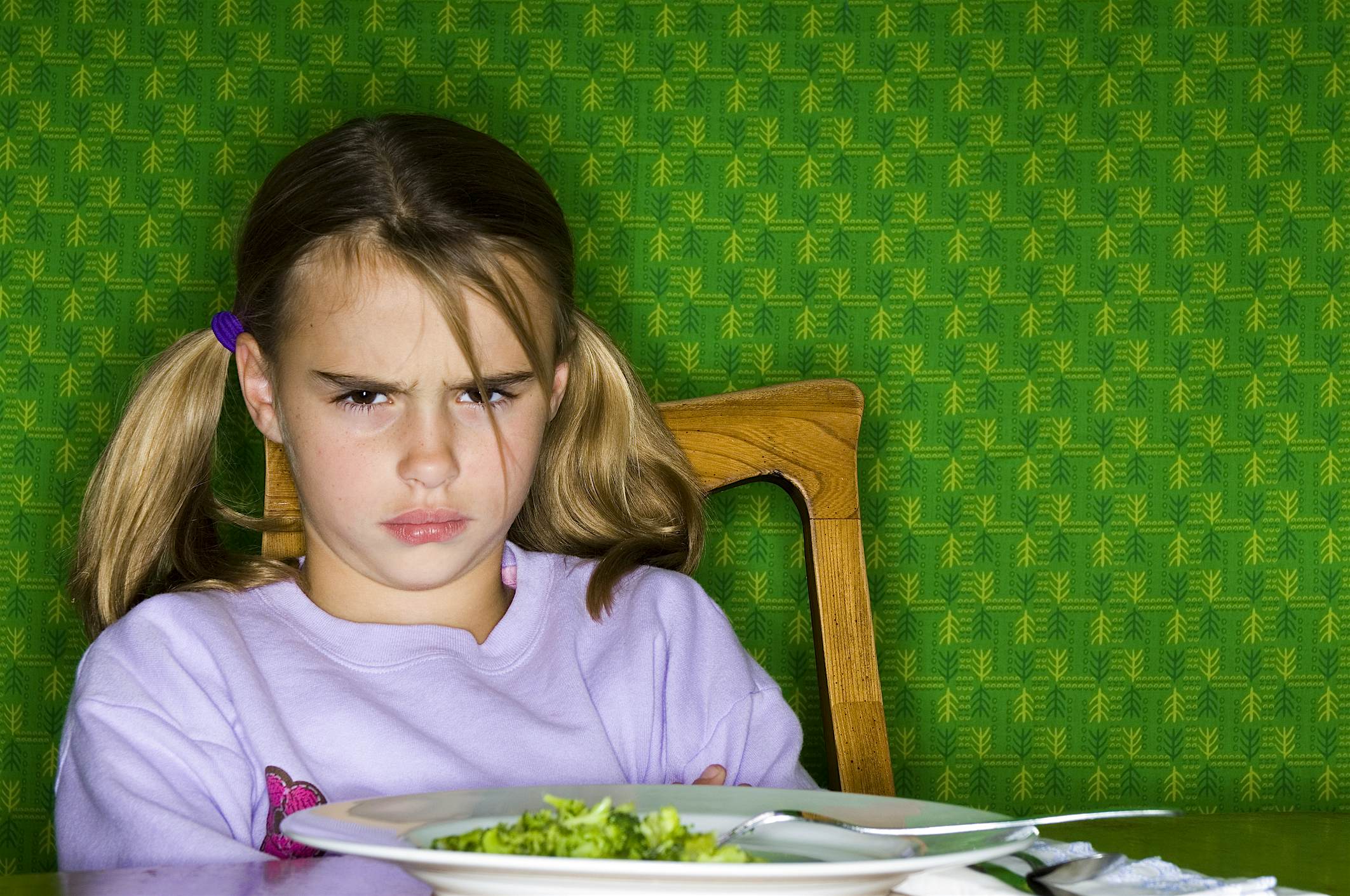 Travel News - Little Girl Sitting at Dinner Table with Plate of Broccoli A Maryland USA restaurant translates responses of moody kids into food they will like. Image: Bonniej