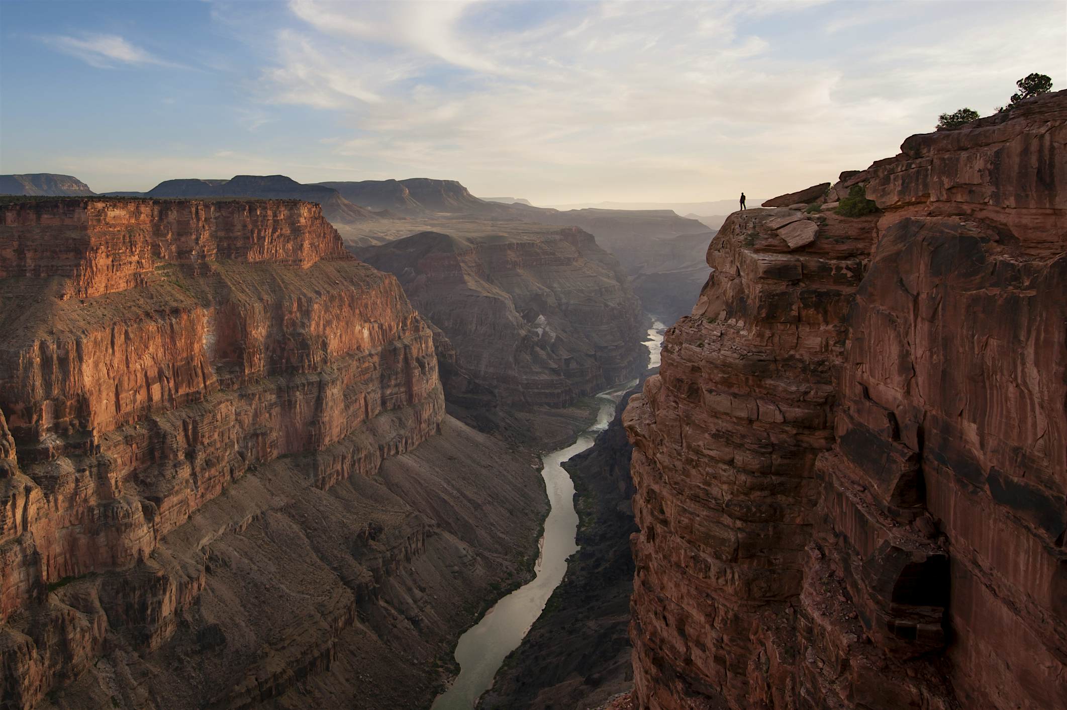 Travel News - A man looking out over a canyon and river. Grand Canyon, Arizona A man looking out over the Grand Canyon at Toroweap Point. Grand Canyon, Arizona