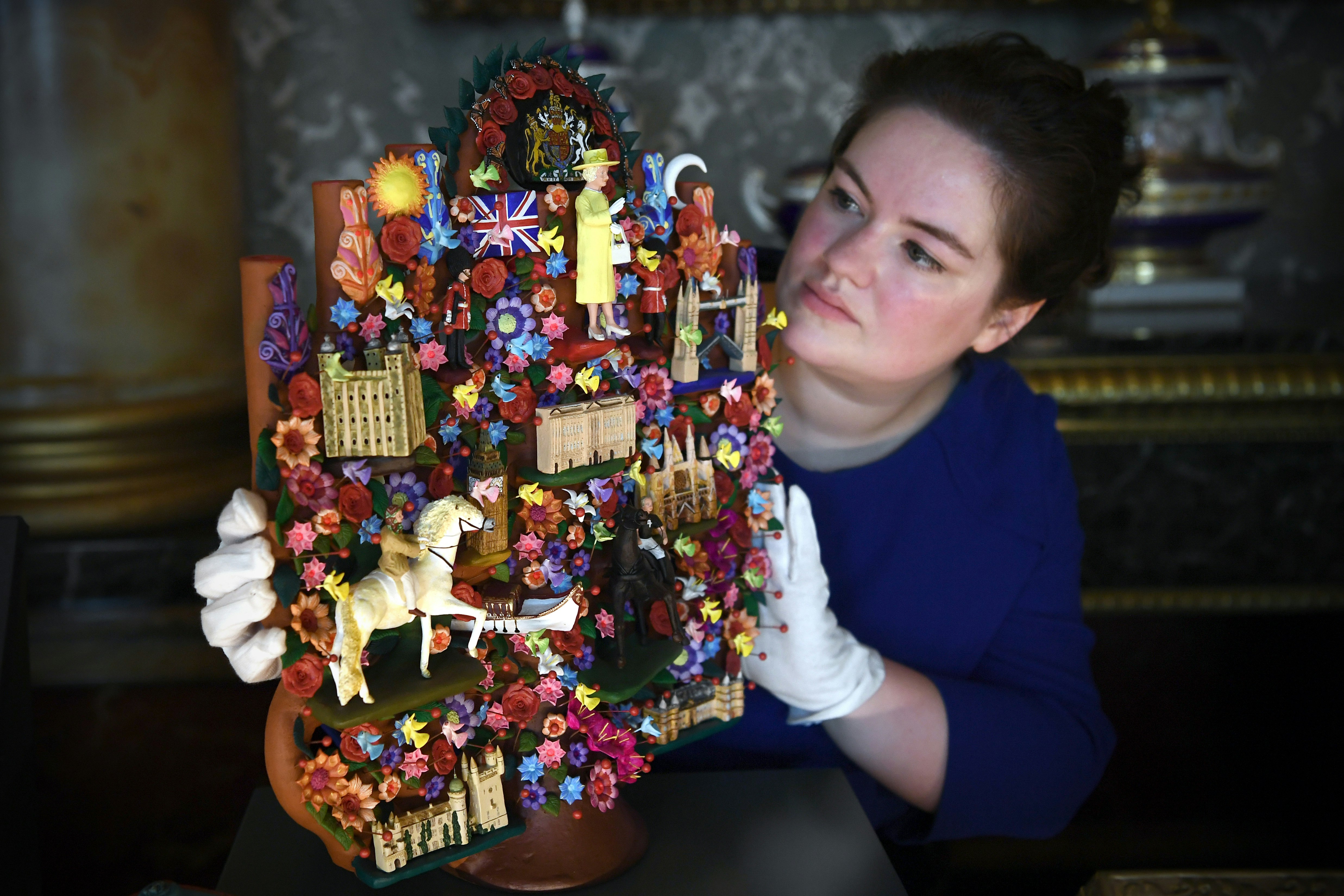 A member of staff poses with a 'Tree of Life' art piece given to Queen Elizabeth II by President Enrique Pena Nieto of Mexico during his 2015 State Visit.