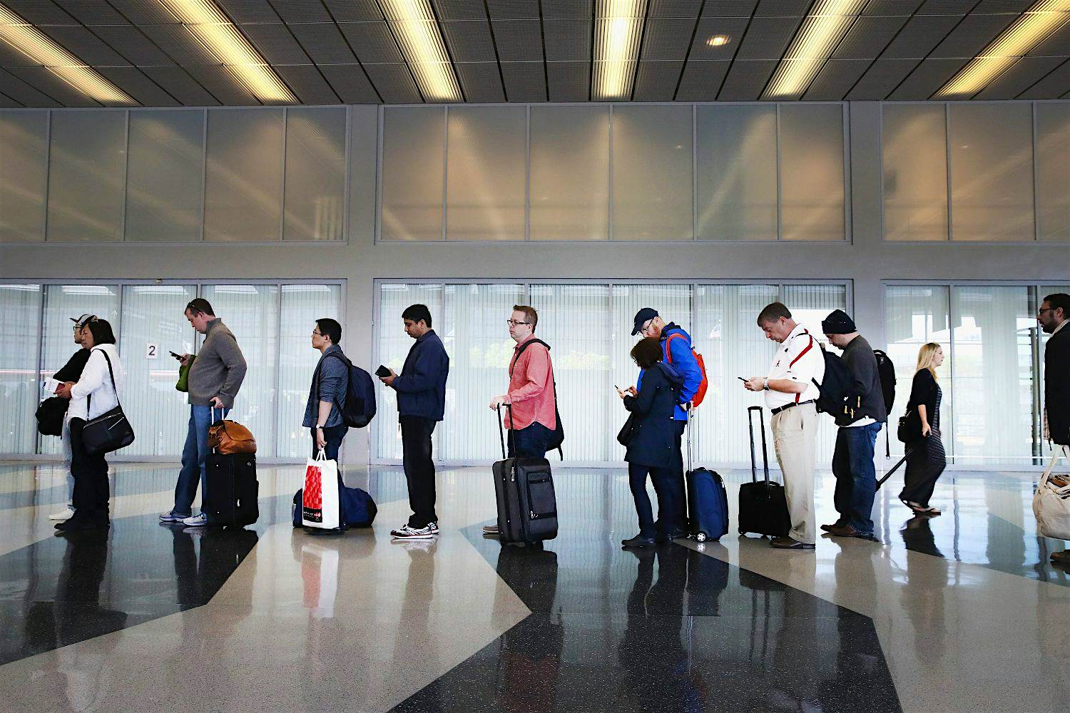 Travel News - As Long Lines In Airports Rise, TSA Struggles To Cut Waiting Times Passengers at O'Hare airport in Chicago wait in line for TSA screening