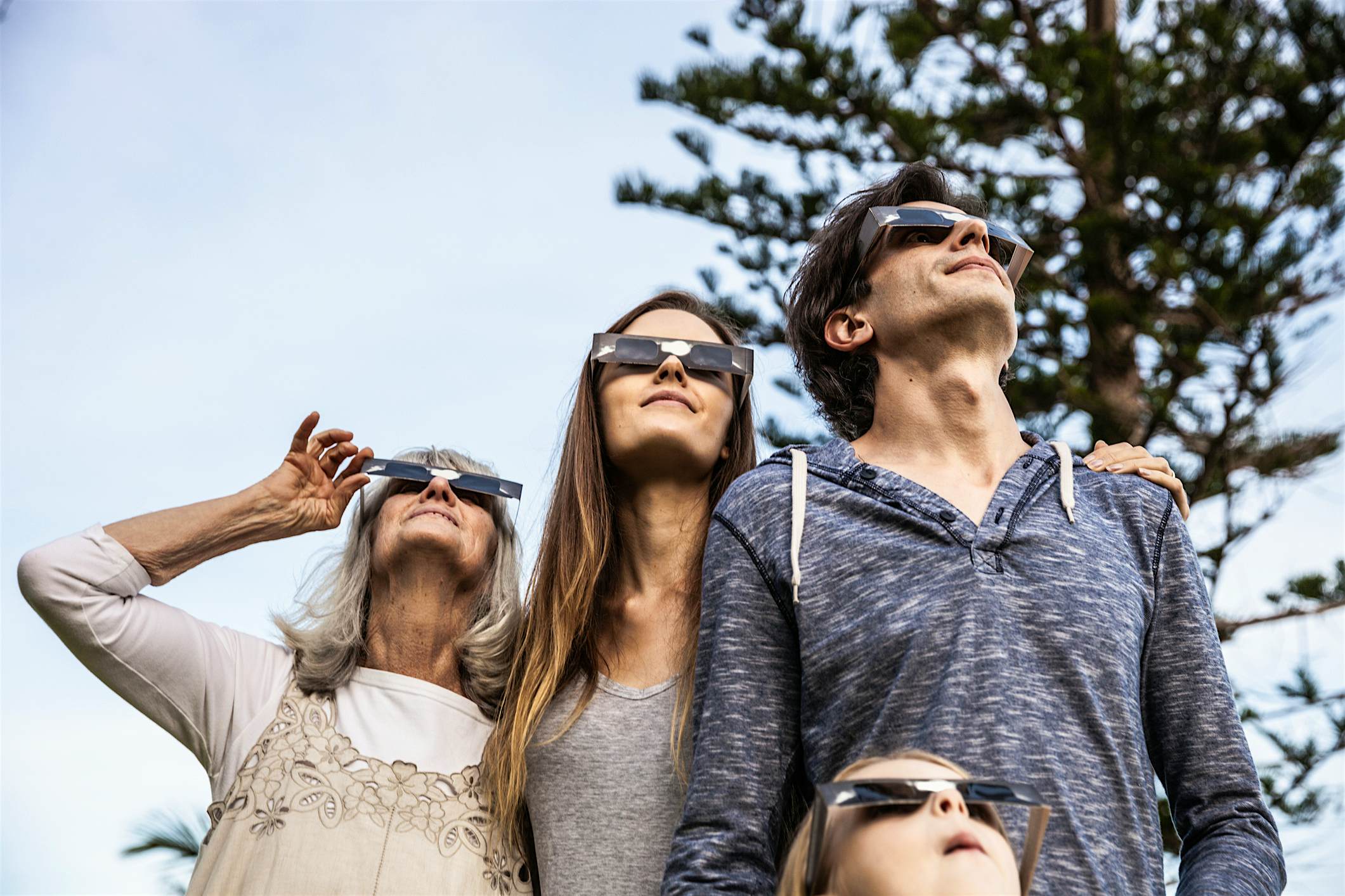 Travel News - eclipse Family looking at Solar Eclipse using solar glasses.