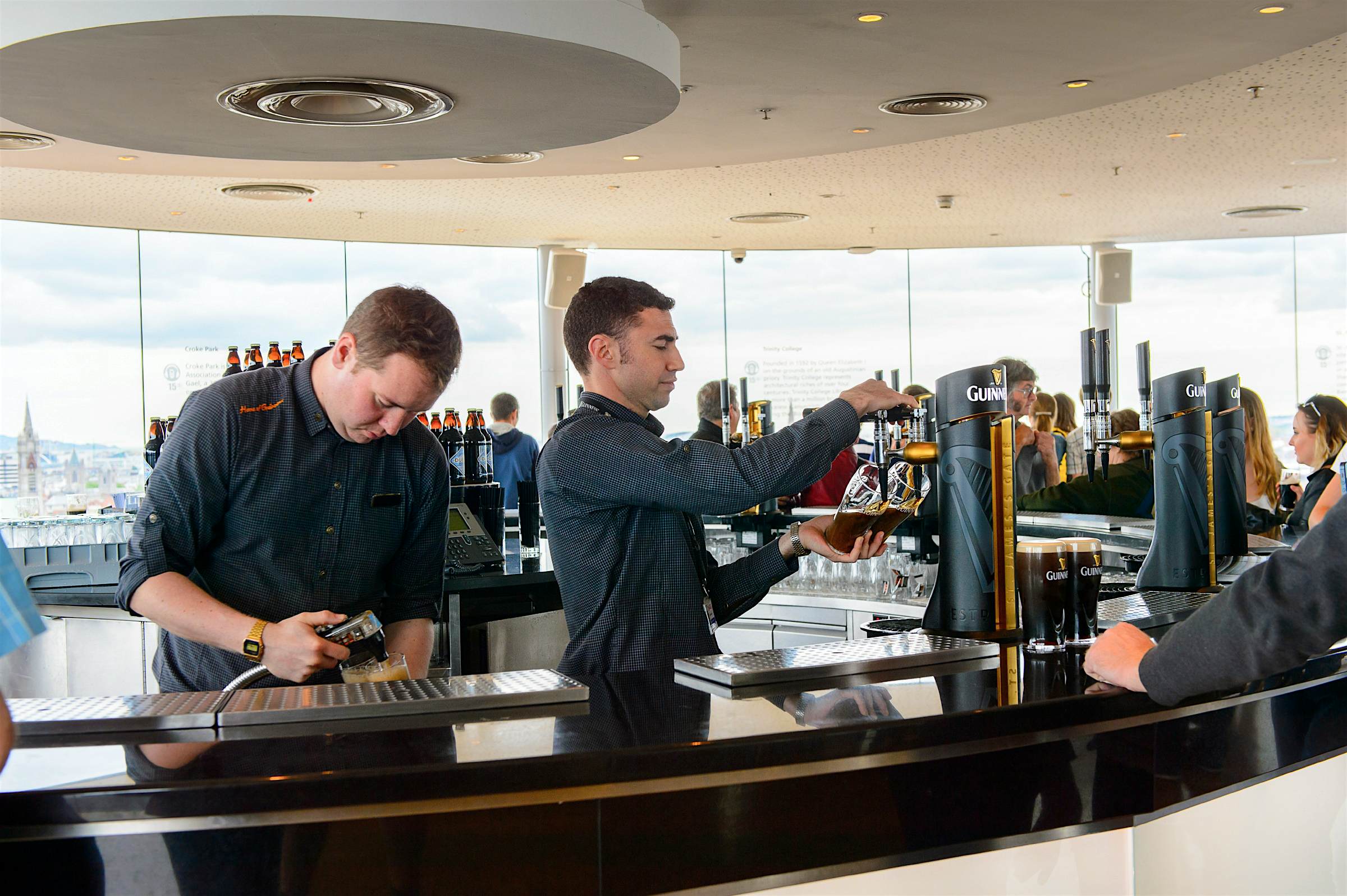 Travel News - guinness storehouse Two men pour pints in the Guinness Storehouse.