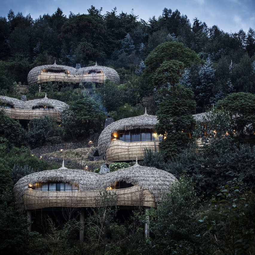 Thatched-roof huts are seen through the foliage in Rwanda.