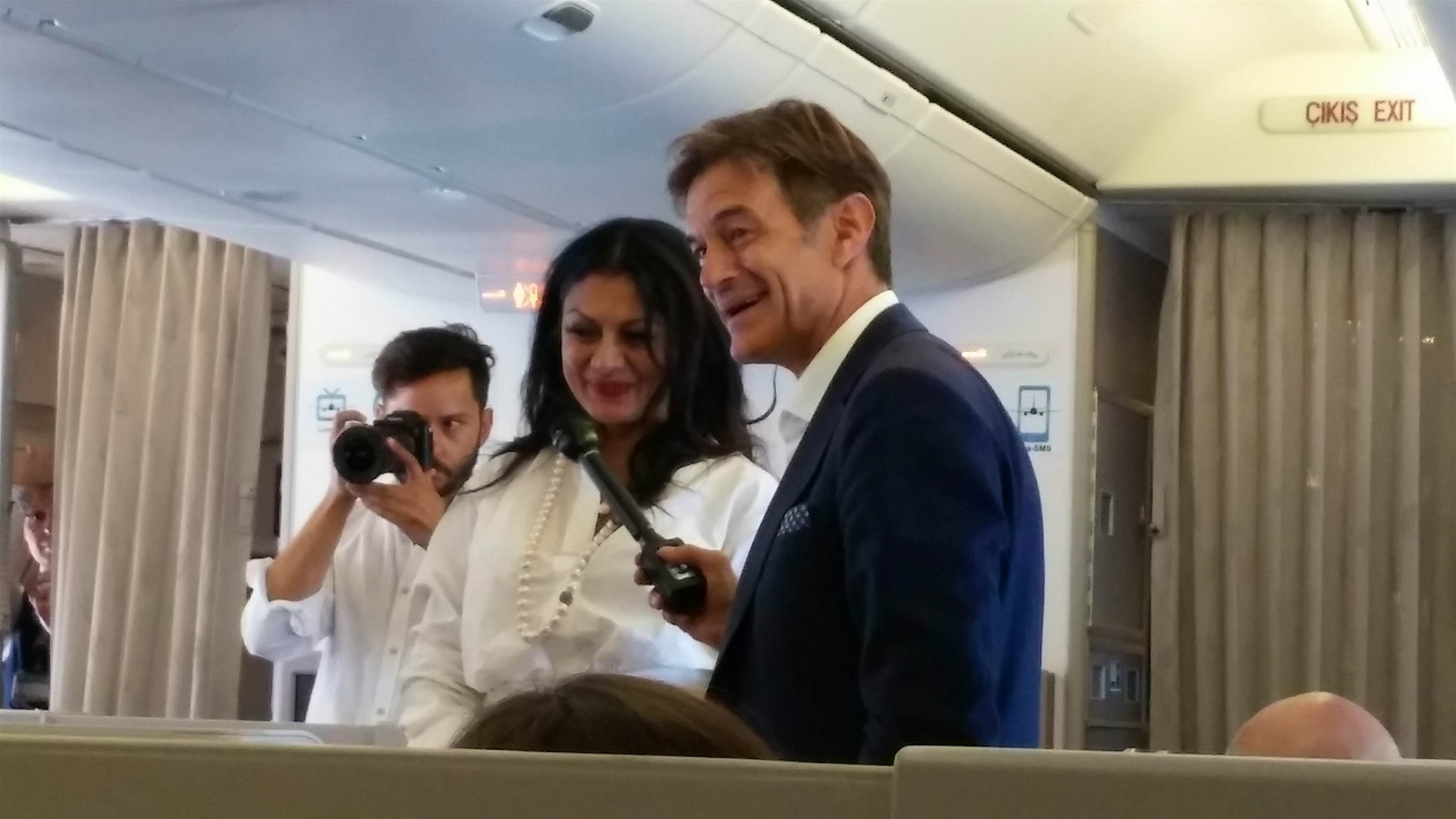 Travel News - Dr. Oz poses with passengers on flight TK01 Turkish Airlines Dr. Oz giving jet-lag tips to passenger on Turkish Airlines flight TK01