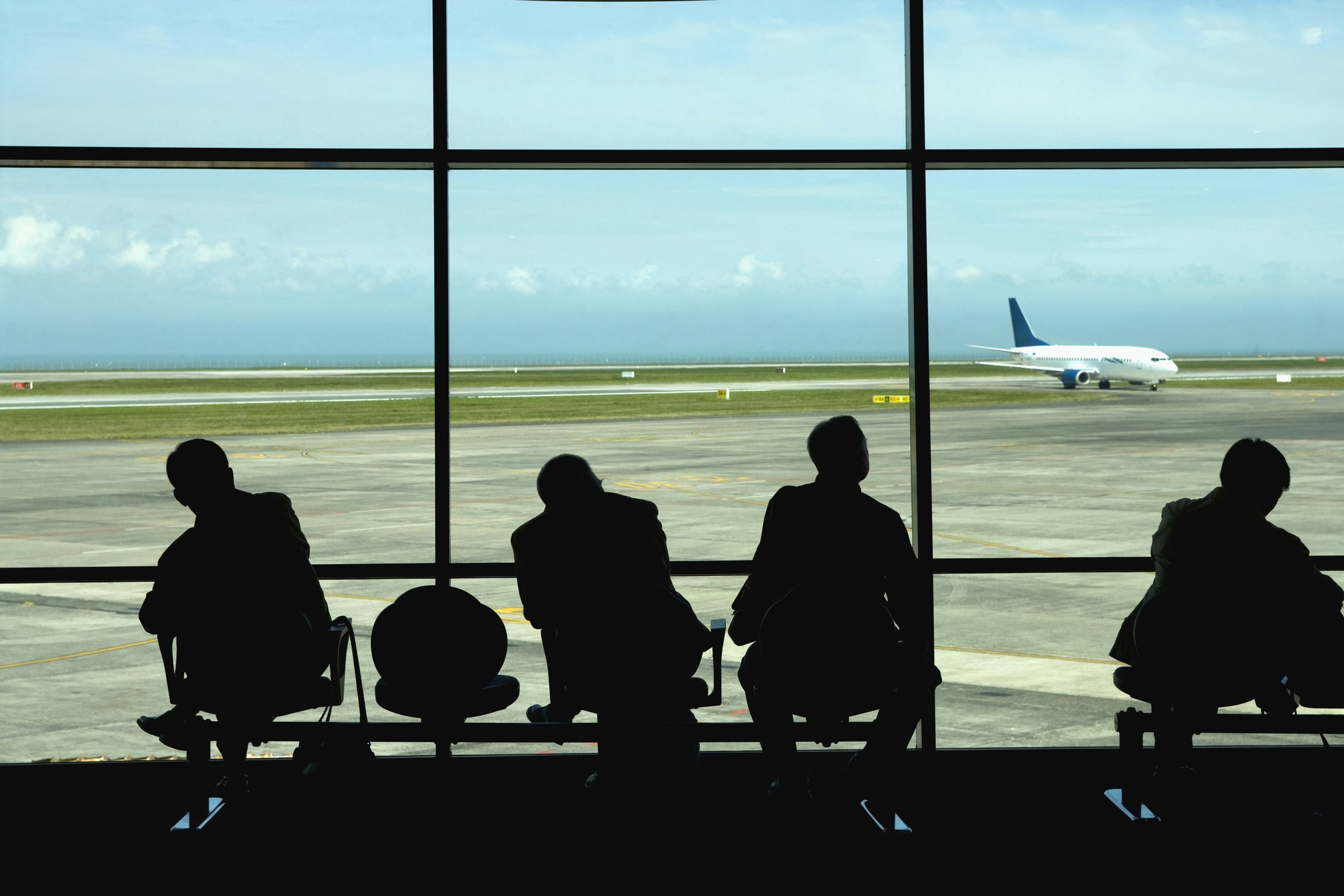 Businessmen watching airplanes on tarmac in airport