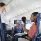 Travel News - Flight attendant serving champagne to passenger