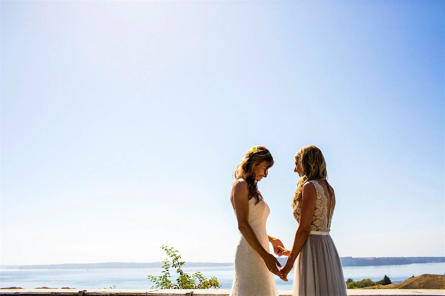 Travel News - Caucasian brides holding hands at waterfront Travel News - Caucasian brides holding hands at waterfront