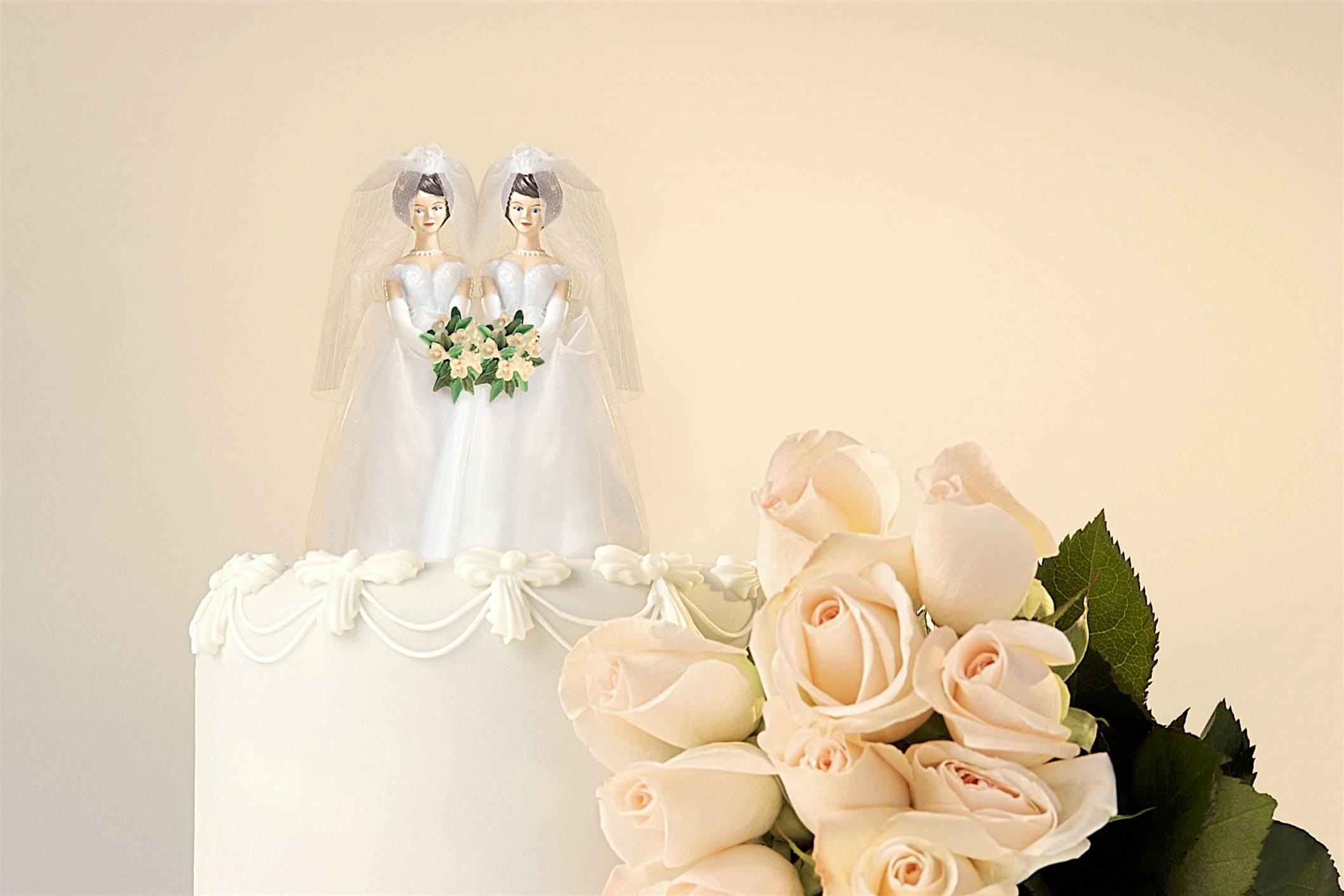 Travel News - Still life of the top of a wedding cake with two miniature brides cake topper and roses at the side Travel News - Still life of the top of a wedding cake with two miniature brides cake topper and roses at the side