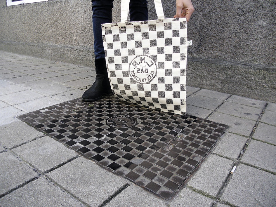 A printed bag being created from a metal street cover in Porto.