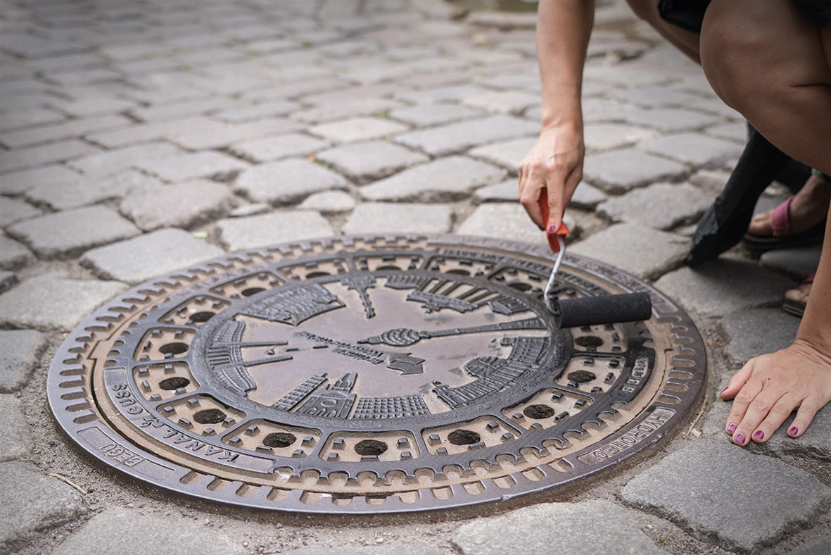 A manhole cover being painted for the raubdruckerin project