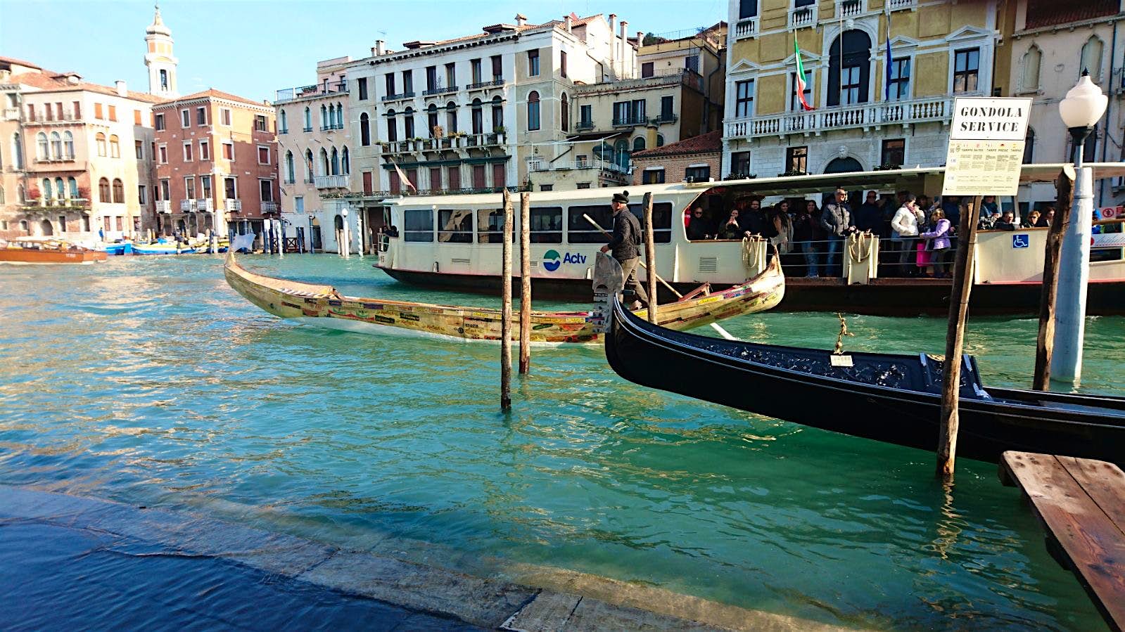 Travel News - Angelo Boscolo on the Grand Canal with his gondola made from used vegetable crates, a classic gondola and a vaporetto Travel News - Angelo Boscolo on the Grand Canal with his gondola made from used vegetable crates, a classic gondola and a vaporetto