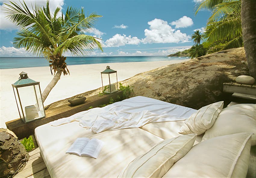 Travel News - Daybed on tropical beach under coconut palms Travel News - Daybed on tropical beach under coconut palms
