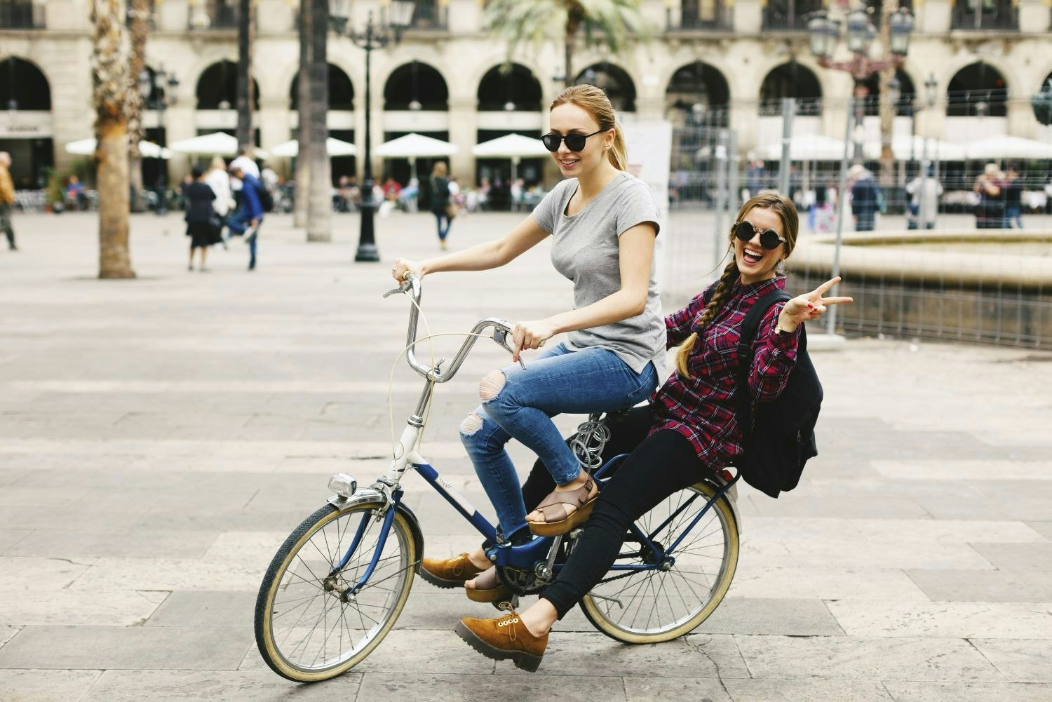 Two young women cycling on one bike