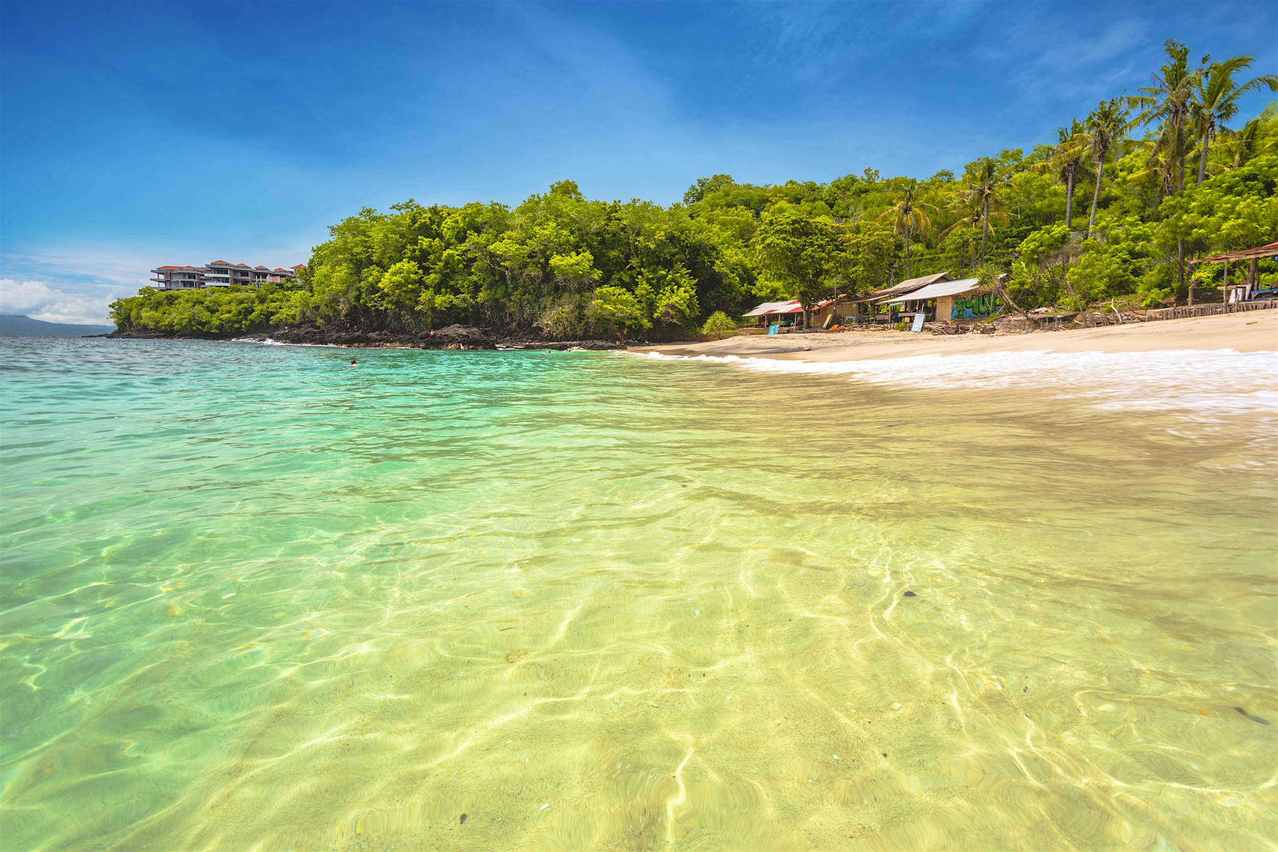 Travel News - Bali Beach Padangbai, Karangasem, Eastern Bali, Indonesia. The tropical shore of the White Sand Beach (Bias Tugel).