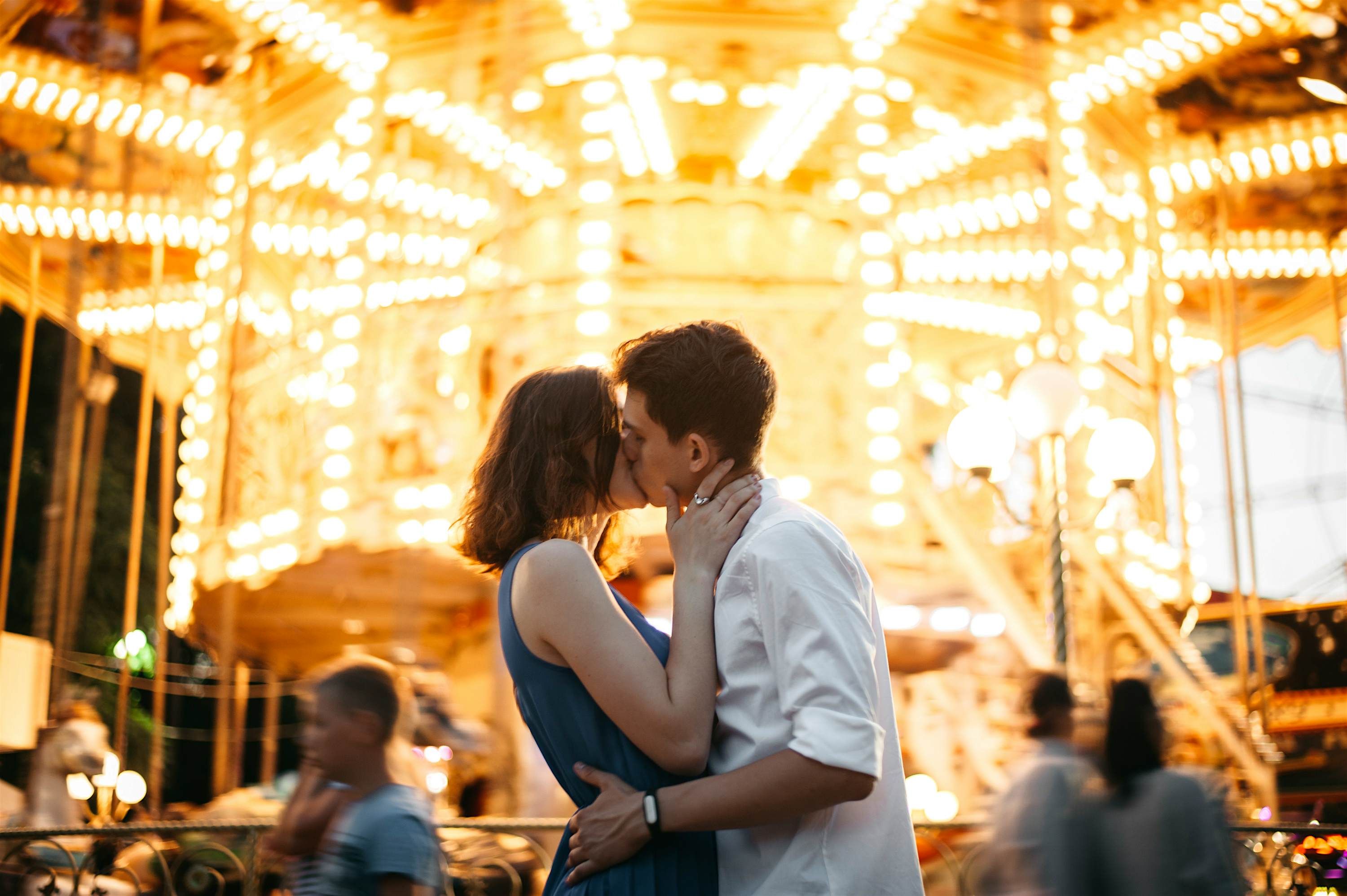 Travel News - Couple kissing near the marry-go-round in the park Young Caucasian heterosexual kissing near the marry-go-round in the park