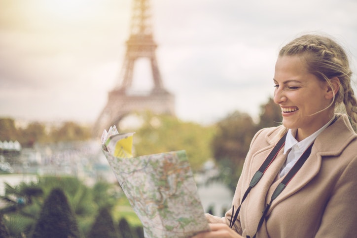 Tourist female in Paris looking at city map, France- Europe