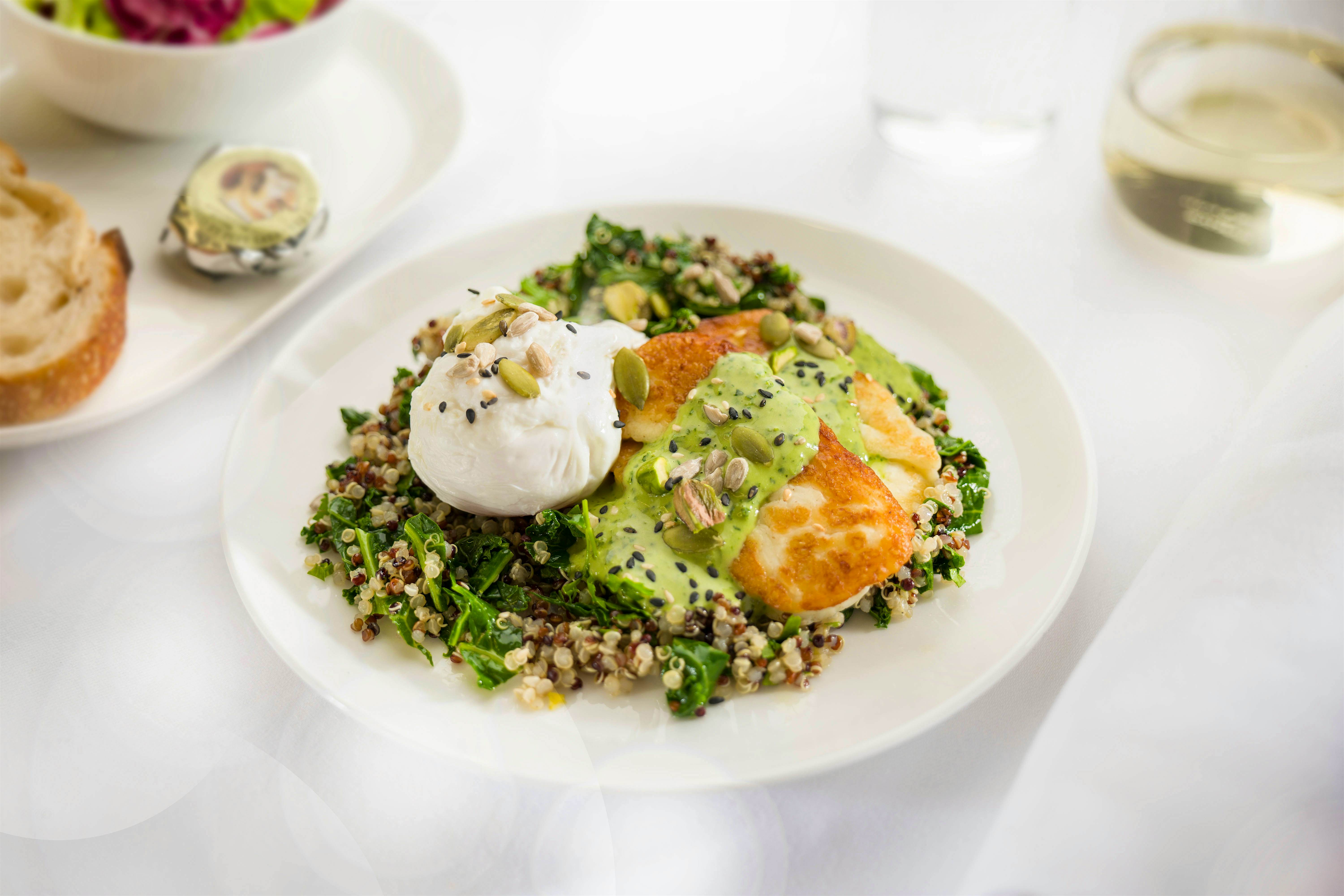 Travel News - Poached eggs with kale, quinoa, grilled haloumi, pistachios, seeds and herbed tahini dressing - Business breakfast menu ex PERLHR B787 QF9 Travel News - Poached eggs with kale, quinoa, grilled haloumi, pistachios, seeds and herbed tahini dressing - Business breakfast menu ex PERLHR B787 QF9