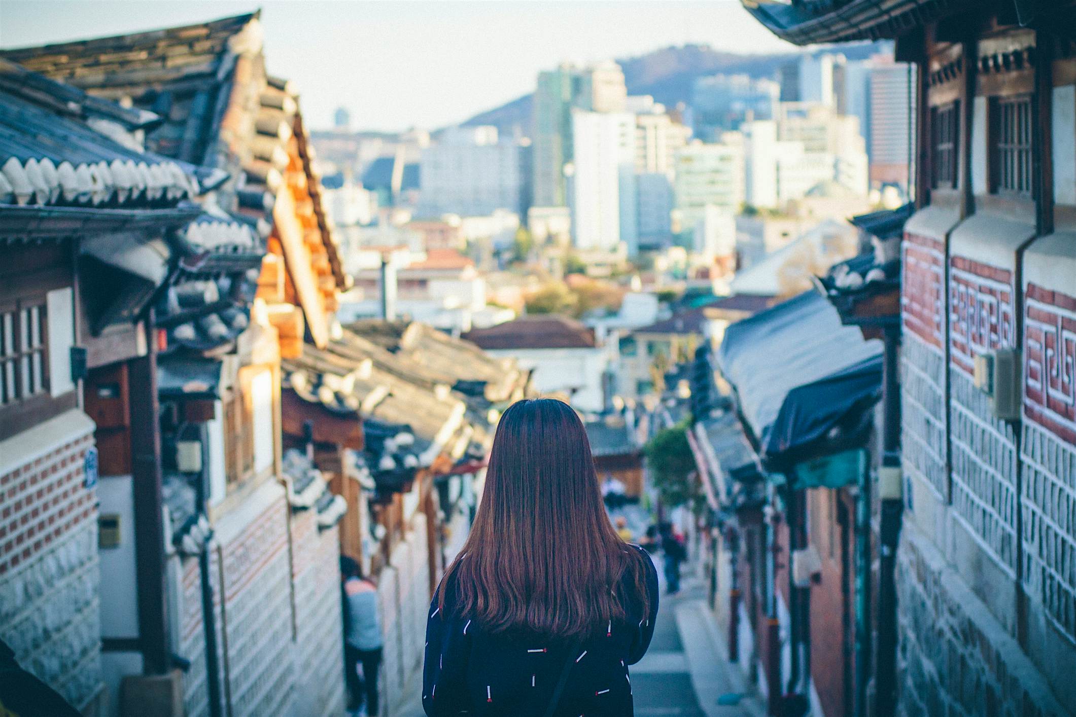 Travel News - Rear View Of Woman In City Travel News - Rear View Of Woman In City