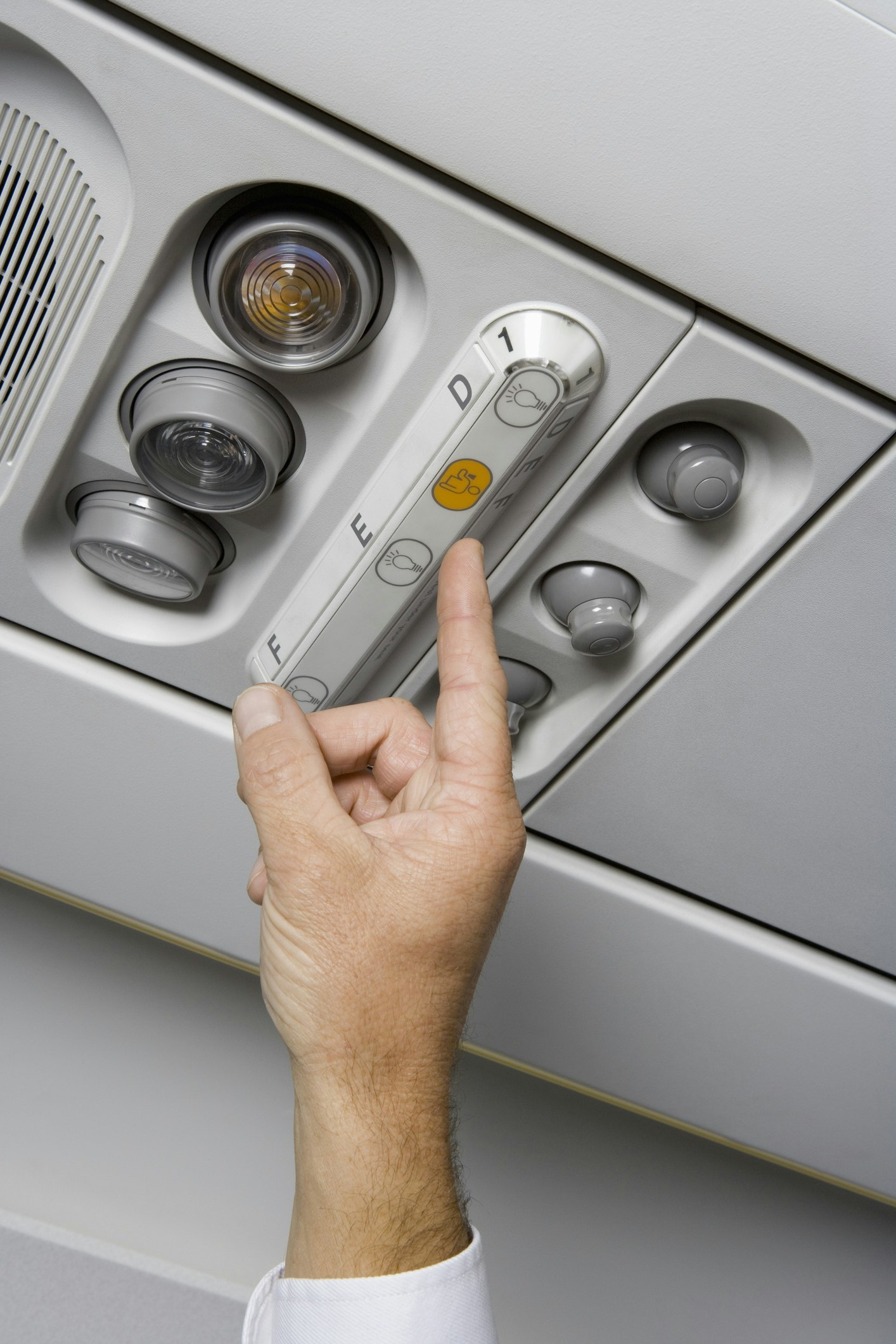 Travel News - A finger pressing the call button on an airplane